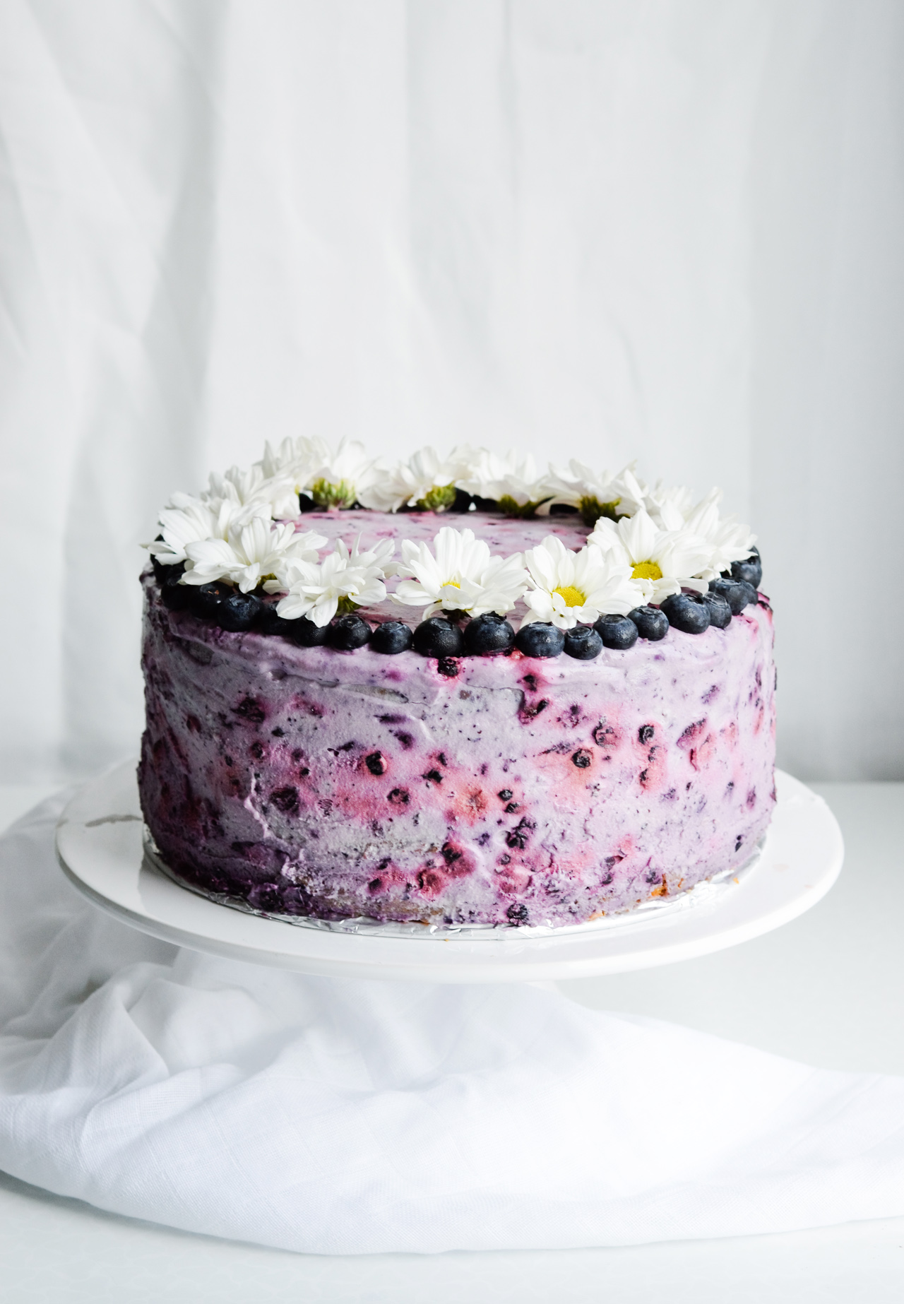 Very blueberry layer cake - a pretty purple sour cream cake with whipped cream and fresh blueberries! Great for birthdays, picnics, parties, weddings.