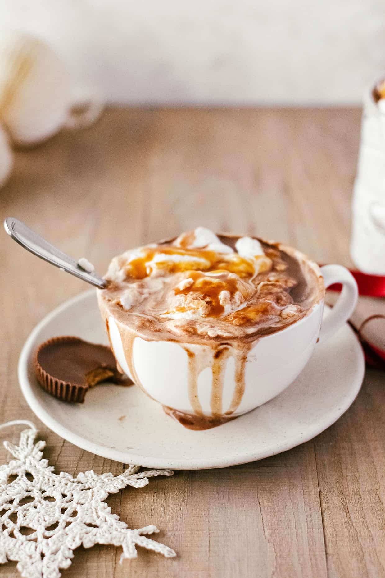 plate with peanut butter cup and mug of hot chocolate spilled over the side