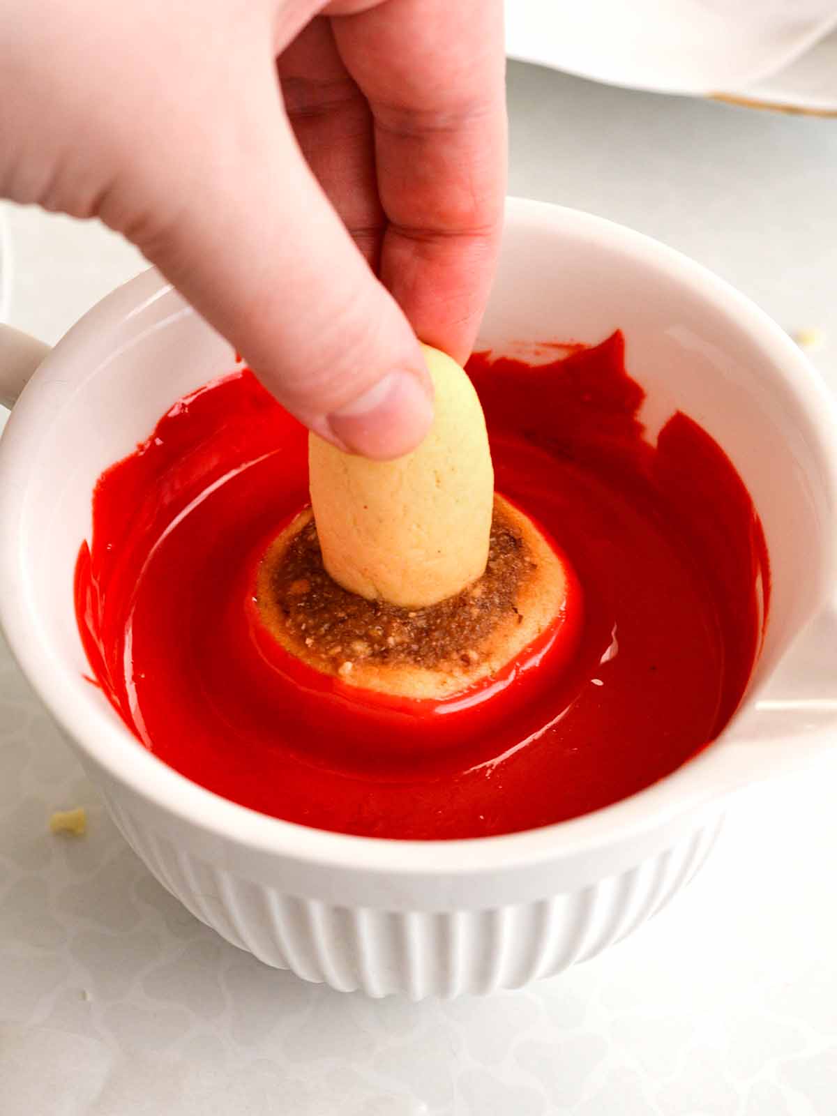 dipping cookie into white chocolate