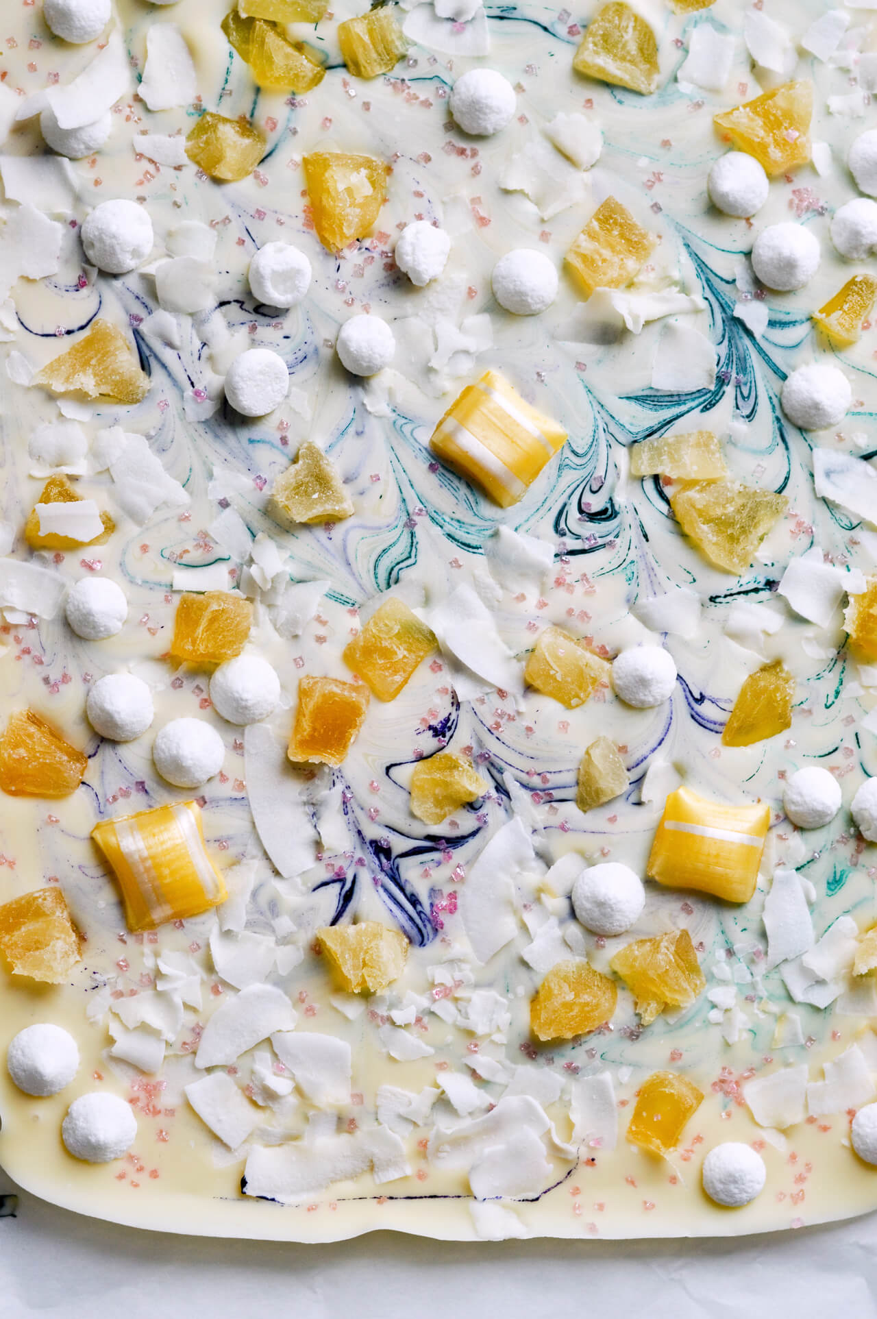 Tropical white chocolate bark with meringues, candied pineapple, coconut chips and sprinkles! Cute dessert or cake topper.