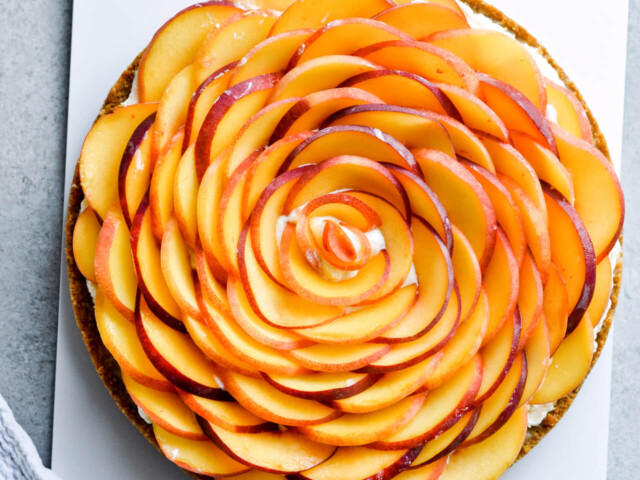 Whipped mascarpone peach tart - crumbly cookie crust filled with vanilla whipped mascarpone and topped with fresh peaches shaped like a rose! A truly impressive dessert. | sugarsalted.com