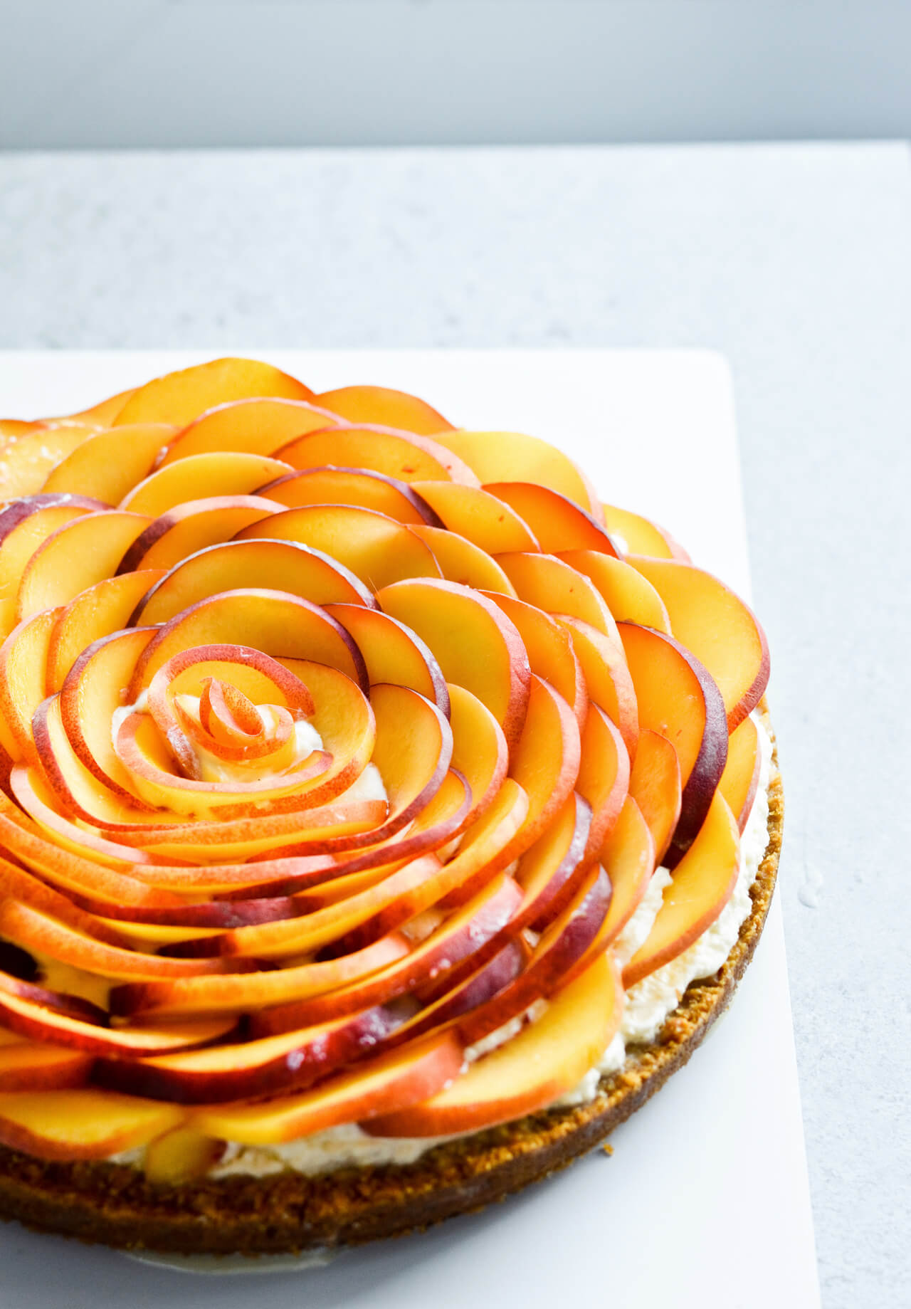 Whipped mascarpone peach tart - crumbly cookie crust filled with vanilla whipped mascarpone and topped with fresh peaches shaped like a rose! A truly impressive dessert. | sugarsalted.com