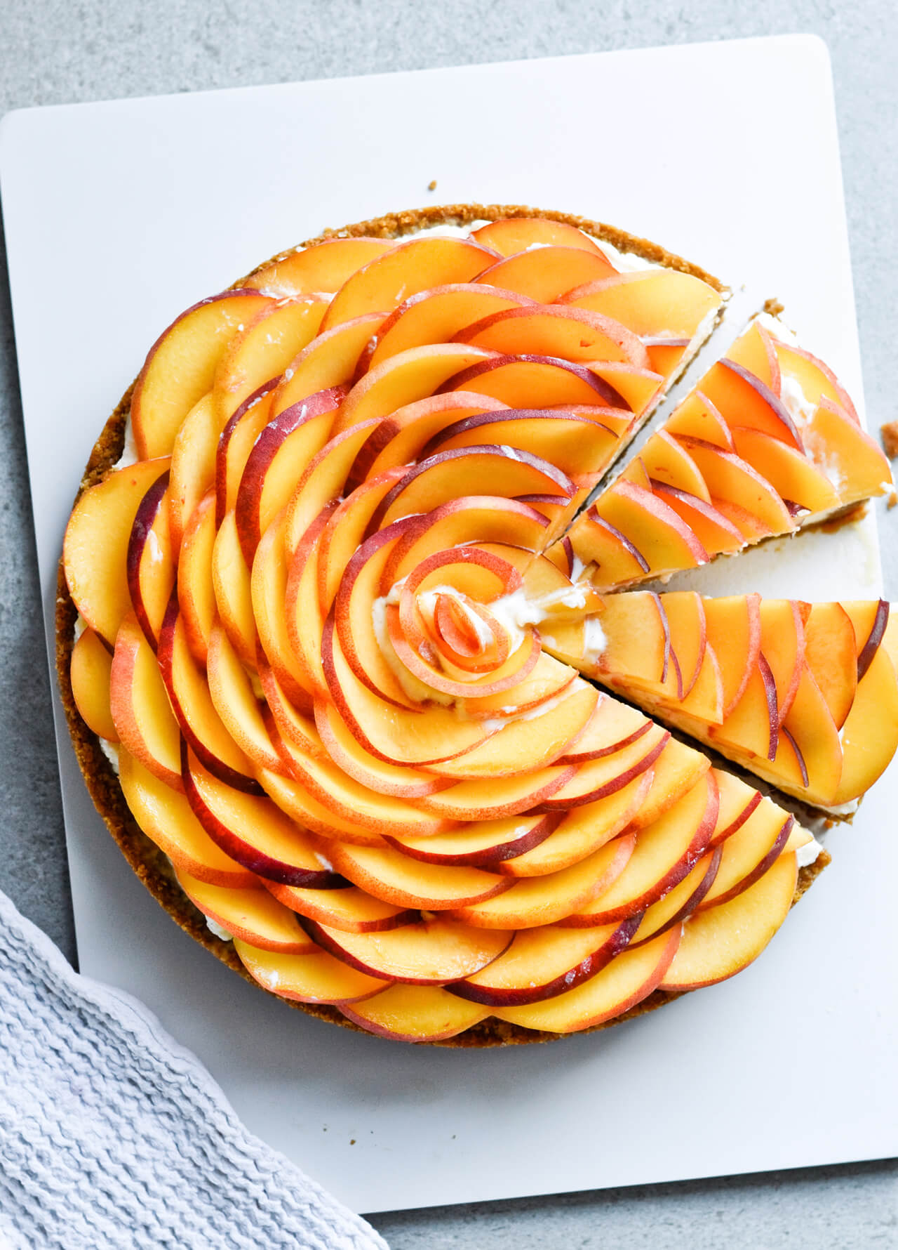 Whipped mascarpone peach tart - crumbly cookie crust filled with vanilla whipped mascarpone and topped with fresh peaches shaped like a rose! A truly impressive dessert. | sugarsalted.com