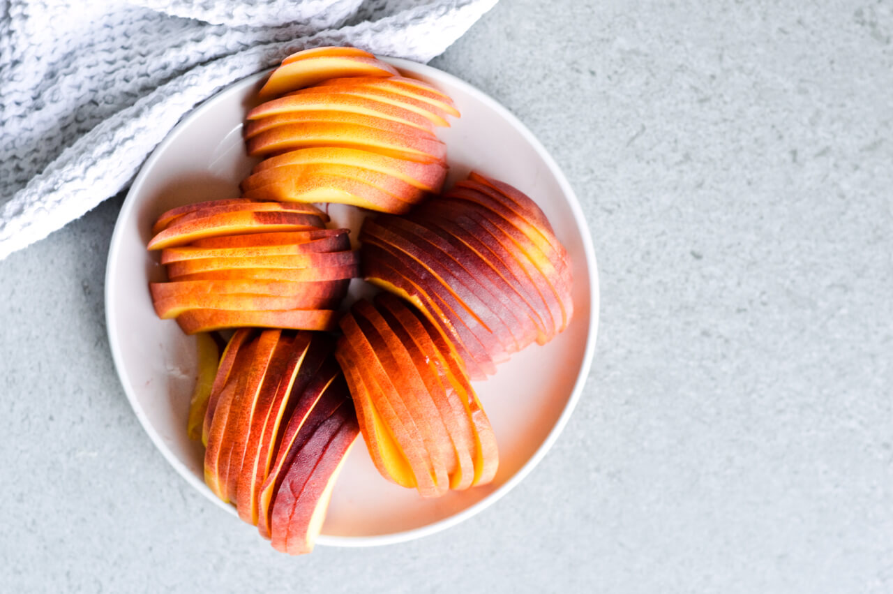 Whipped mascarpone peach tart - crumbly cookie crust filled with vanilla whipped mascarpone and topped with fresh peaches shaped like a rose! A truly impressive dessert. | sugarsalted.com