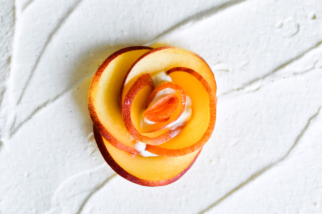 Whipped mascarpone peach tart - crumbly cookie crust filled with vanilla whipped mascarpone and topped with fresh peaches shaped like a rose! A truly impressive dessert. | sugarsalted.com