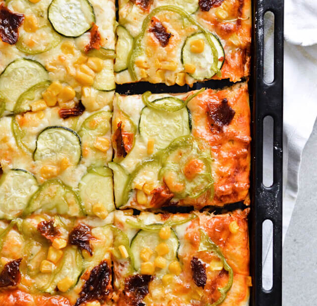 Best vegetable sheet pizza! Made with homemade pizza dough and quick pizza sauce, topped with zucchini, peppers, corn and much more! So easy to make, great for dinner and a crowd. | sugarsalted.com