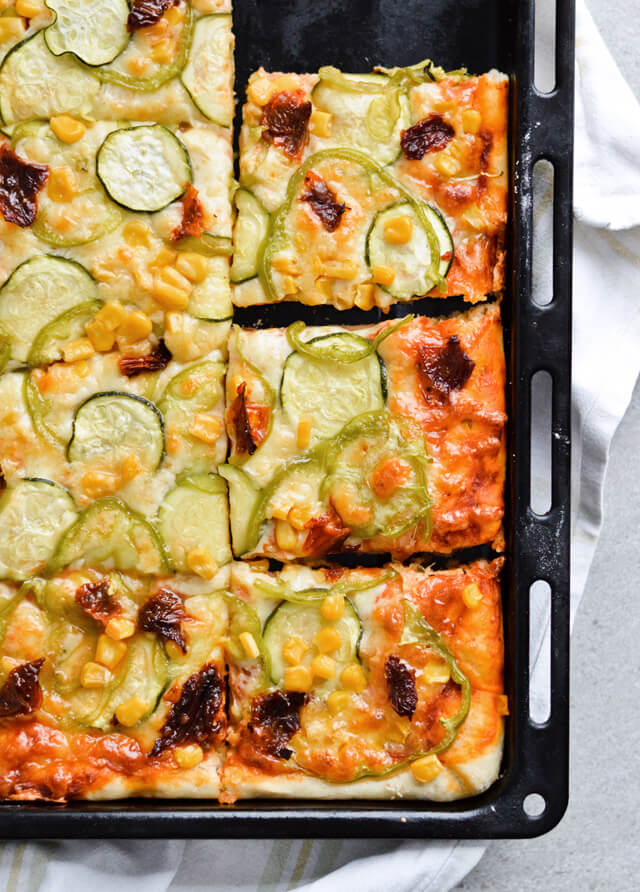 Best vegetable sheet pizza! Made with homemade pizza dough and quick pizza sauce, topped with zucchini, peppers, corn and much more! So easy to make, great for dinner and a crowd. | sugarsalted.com