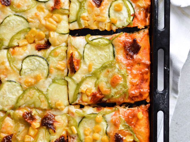 Best vegetable sheet pizza! Made with homemade pizza dough and quick pizza sauce, topped with zucchini, peppers, corn and much more! So easy to make, great for dinner and a crowd. | sugarsalted.com