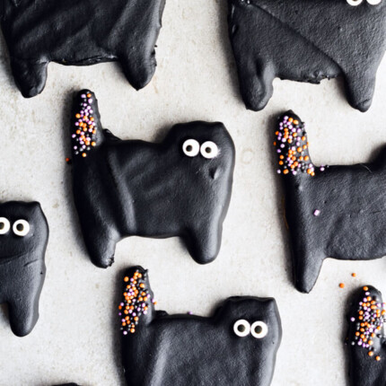 Dark chocolate cat cookies, perfect for Halloween! Or just any other fun day of the year. Sugar cookies coated with black dark chocolate and lots of sprinkles. | sugarsalted.com