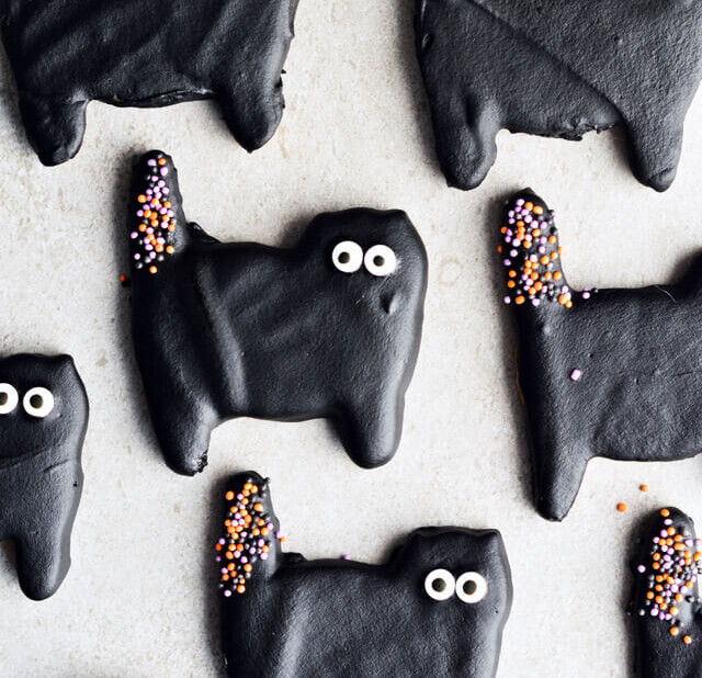Dark chocolate cat cookies, perfect for Halloween! Or just any other fun day of the year. Sugar cookies coated with black dark chocolate and lots of sprinkles. | sugarsalted.com