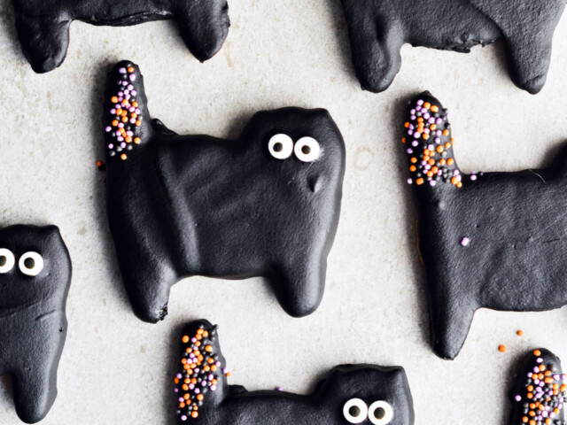 Dark chocolate cat cookies, perfect for Halloween! Or just any other fun day of the year. Sugar cookies coated with black dark chocolate and lots of sprinkles. | sugarsalted.com