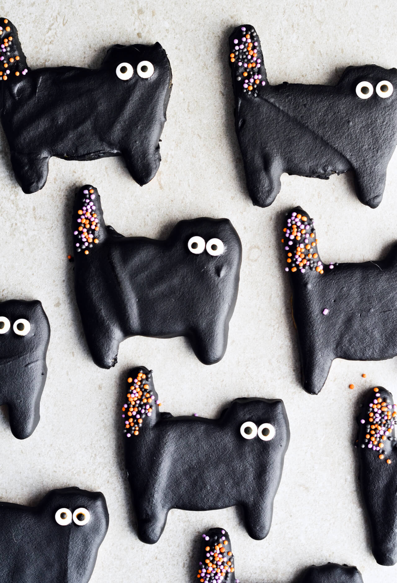 Dark chocolate cat cookies, perfect for Halloween! Or just any other fun day of the year. Sugar cookies coated with black dark chocolate and lots of sprinkles. | sugarsalted.com