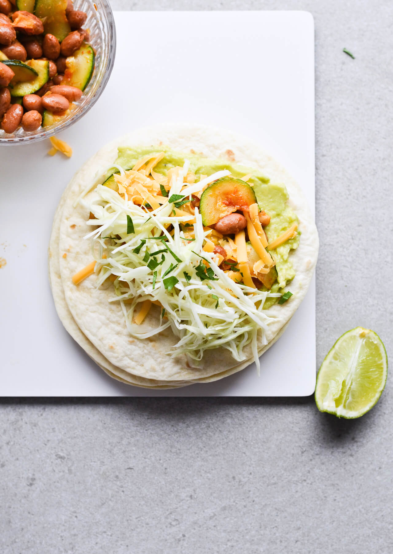 Guacamole cabbage bean tacos are the best vegetarian tacos! With easy homemade guacamole, zesty cabbage, zucchini, paprika beans and lots of cheddar! | sugarsalted.com