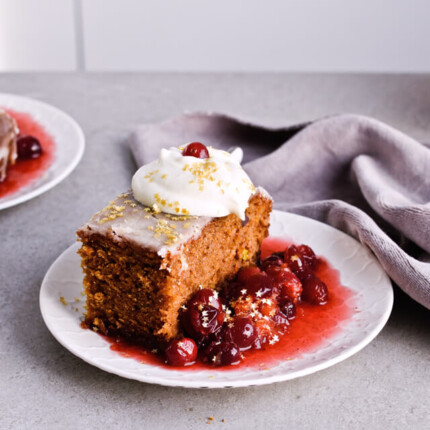 Recipe for Citrus pistachio spice cake with lemon sugar glaze, cranberry compote and homemade whipped cream. Full of cinnamon and cardamom, it almost tastes like lebkuchen. Perfect holiday treat, can be made ahead. | sugarsalted.com