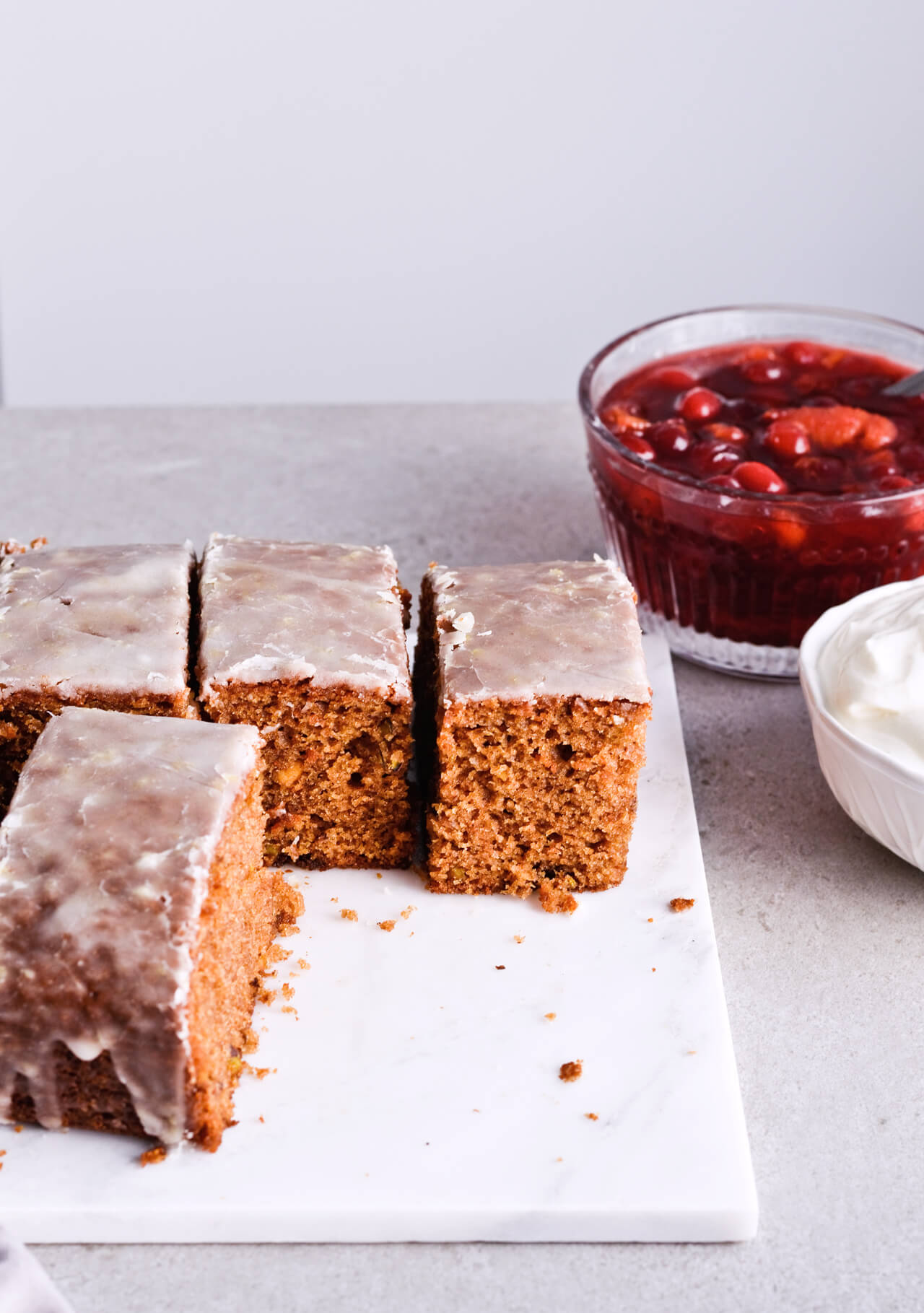 Recipe for Citrus pistachio spice cake with lemon sugar glaze, cranberry compote and homemade whipped cream. Full of cinnamon and cardamom, it almost tastes like lebkuchen. Perfect holiday treat, can be made ahead. | sugarsalted.com