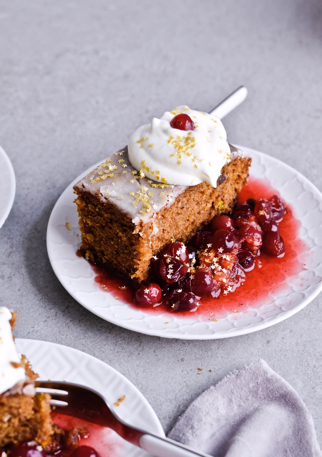 Recipe for Citrus pistachio spice cake with lemon sugar glaze, cranberry compote and homemade whipped cream. Full of cinnamon and cardamom, it almost tastes like lebkuchen. Perfect holiday treat, can be made ahead. | sugarsalted.com