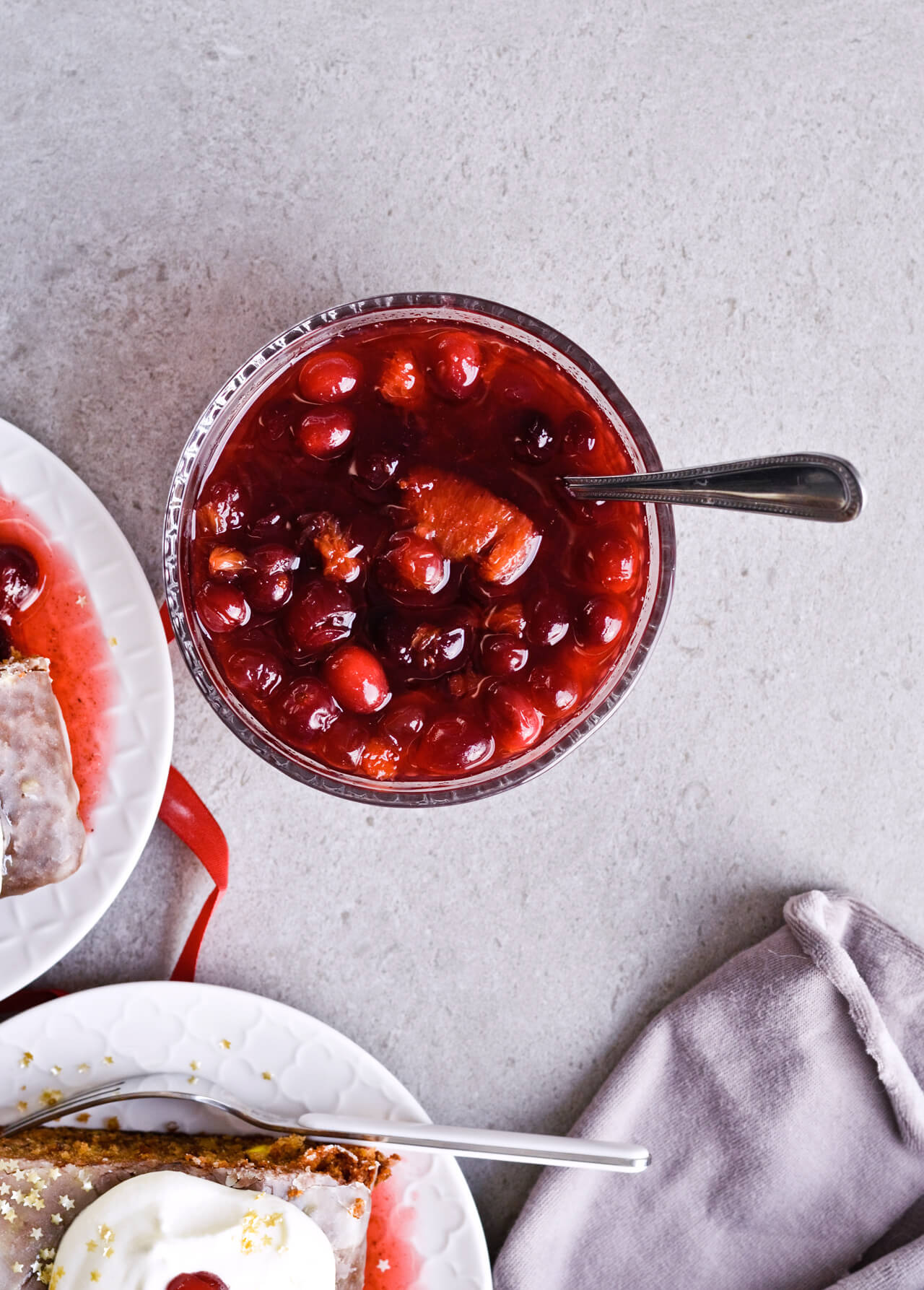 Orange cranberry compote with maple syrup, made for Citrus pistachio spice cake with lemon sugar glaze and homemade whipped cream. Full of cinnamon and cardamom, it almost tastes like lebkuchen. Perfect holiday treat, can be made ahead. | sugarsalted.com