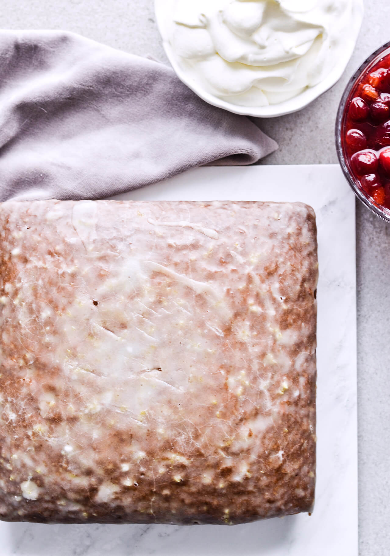 Recipe for Citrus pistachio spice cake with lemon sugar glaze, cranberry compote and homemade whipped cream. Full of cinnamon and cardamom, it almost tastes like lebkuchen. Perfect holiday treat, can be made ahead. | sugarsalted.com