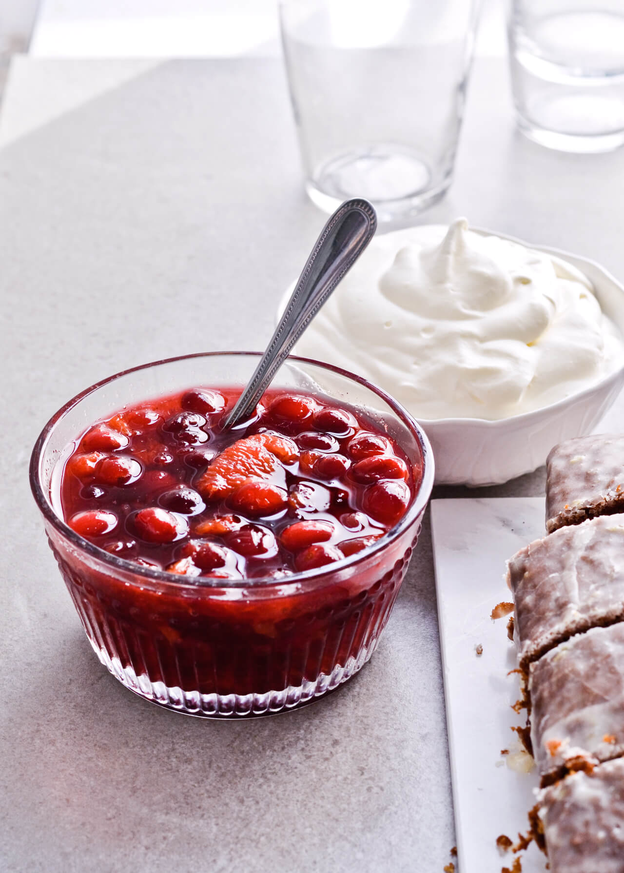 Orange cranberry compote with maple syrup for Citrus pistachio spice cake with lemon sugar glaze and homemade whipped cream. Full of cinnamon and cardamom, it almost tastes like lebkuchen. Perfect holiday treat, can be made ahead. | sugarsalted.com