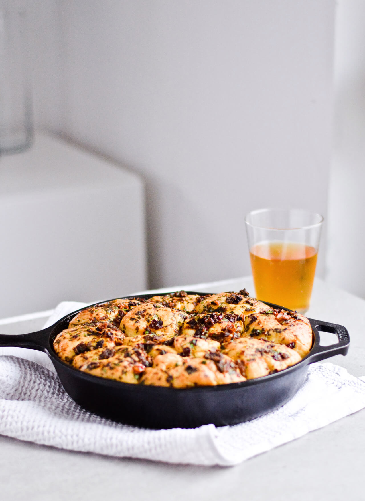 Recipe for sun-dried tomato herb skillet rolls. Dough infused with oregano and rolls drenched with parsley butter and sun-dried tomatoes. Soft, individual rolls straight from the skillet, great for the holiday dinner table. | sugarsalted.com