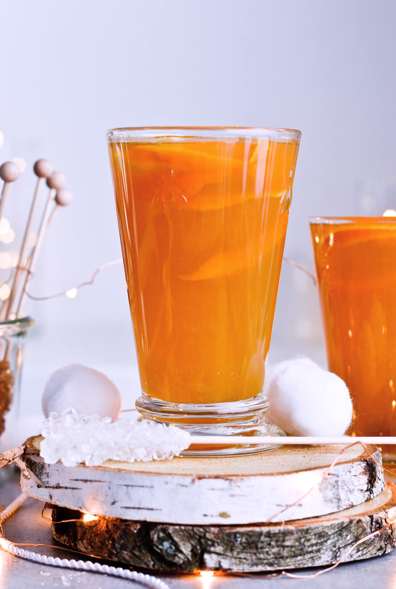 Recipe for Winter tea rum punch, the perfect winter cozy drink! Made with orange juice, honey, ginger beer and cinnamon baked apple teas! Served with orange twists and sugar swizzle sticks. A great cocktail made in 15 minutes! | @mitzyathome sugarsalted.com