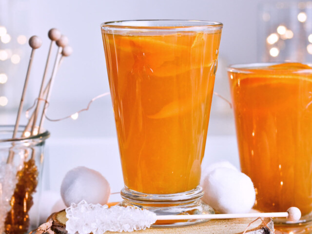Recipe for Winter tea rum punch, the perfect winter cozy drink! Made with orange juice, honey, ginger beer and cinnamon baked apple teas! Served with orange twists and sugar swizzle sticks. A great cocktail made in 15 minutes! | @mitzyathome sugarsalted.com