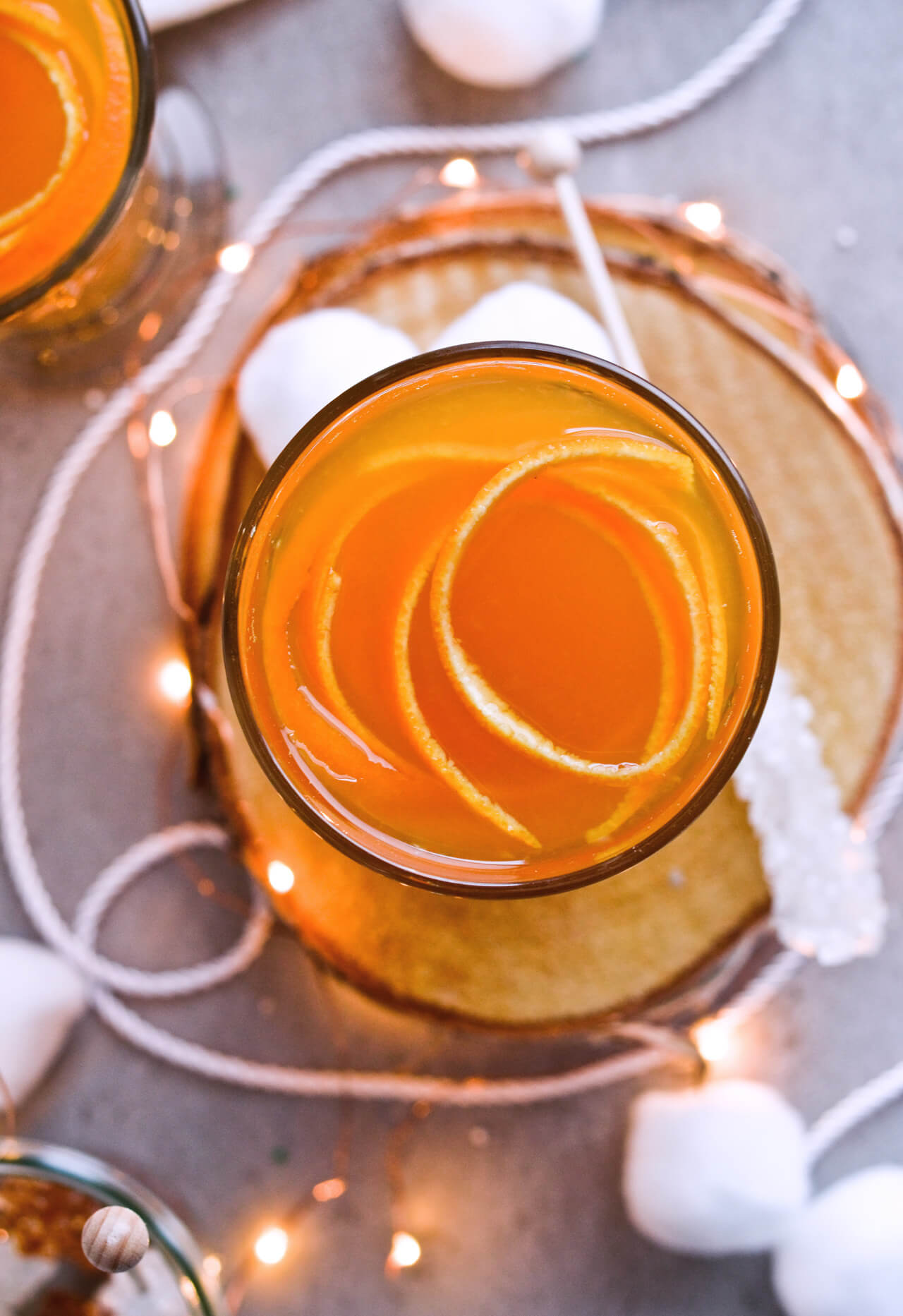 Recipe for Winter tea rum punch, the perfect winter cozy drink! Made with orange juice, honey, ginger beer and cinnamon baked apple teas! Served with orange twists and sugar swizzle sticks. A great cocktail made in 15 minutes! | @mitzyathome sugarsalted.com