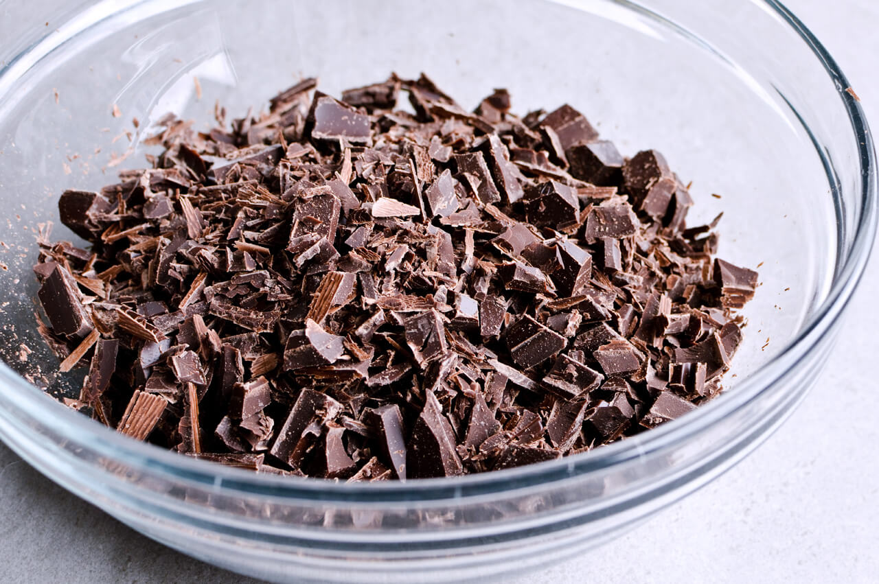 Recipe for Chocolate lover's triple chocolate ganache layer cake, every chocoholic's dream come true! Made with coffee, rich bittersweet chocolate and cream, but no butter, this chocolate cake is smooth and addicting! Topped with sprinkles and flowers, to make it super pretty. | sugarsalted.com