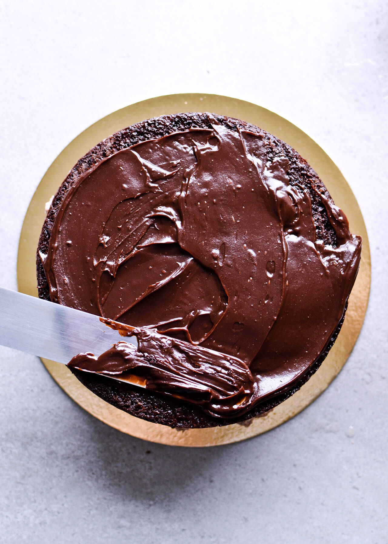 Recipe for Chocolate lover's triple chocolate ganache layer cake, every chocoholic's dream come true! Made with coffee, rich bittersweet chocolate and cream, but no butter, this chocolate cake is smooth and addicting! Topped with sprinkles and flowers, to make it super pretty. | sugarsalted.com