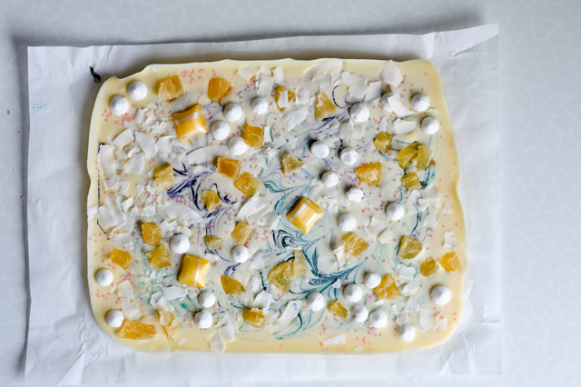 Tropical white chocolate bark with meringues, candied pineapple, coconut chips and sprinkles! Cute dessert or cake topper.