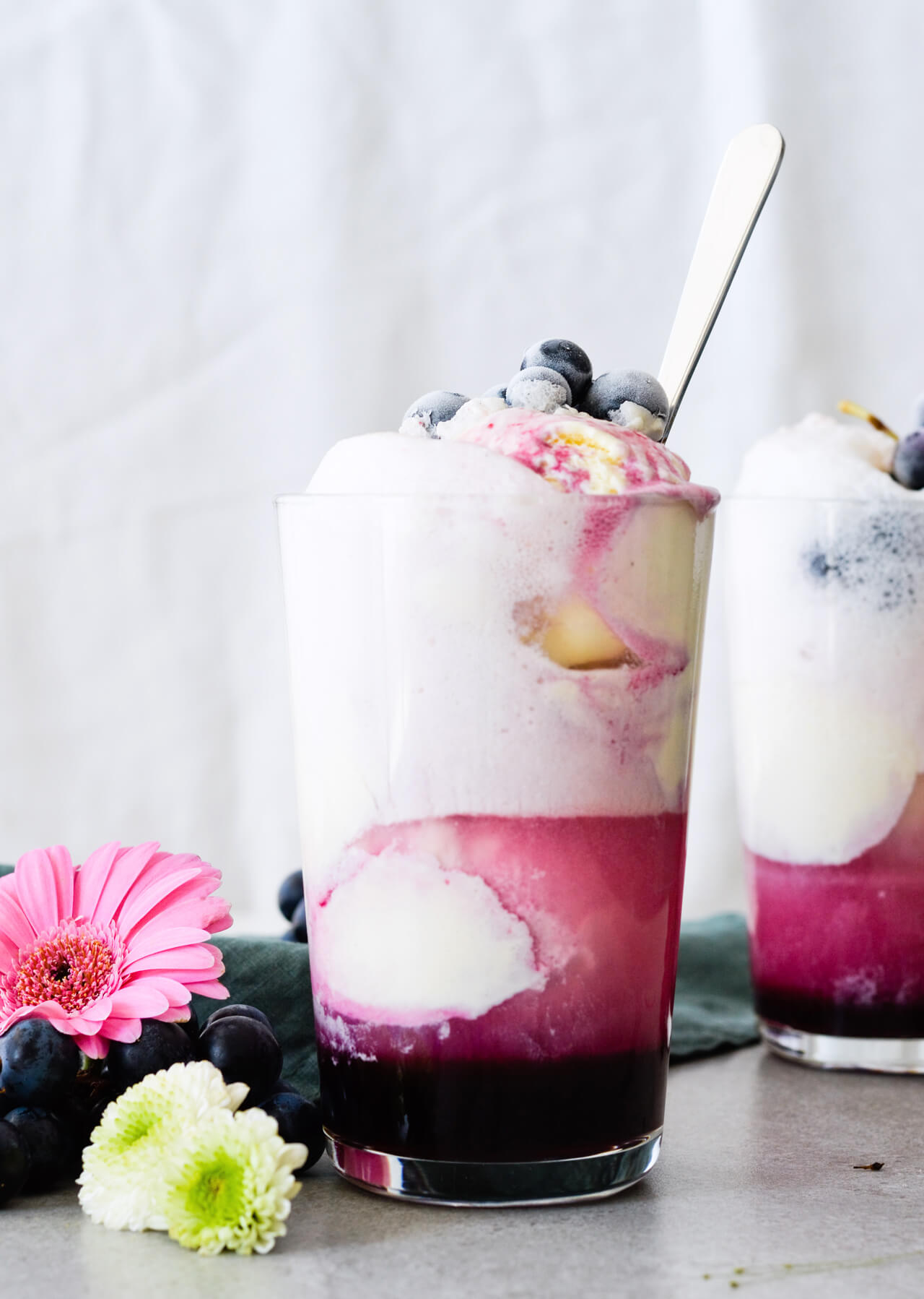 Concord grape syrup ginger beer floats will make you feel like a child again! Made with easy homemade syrup and lots of vanilla ice cream, these make the perfect early Fall - Autumn treat.