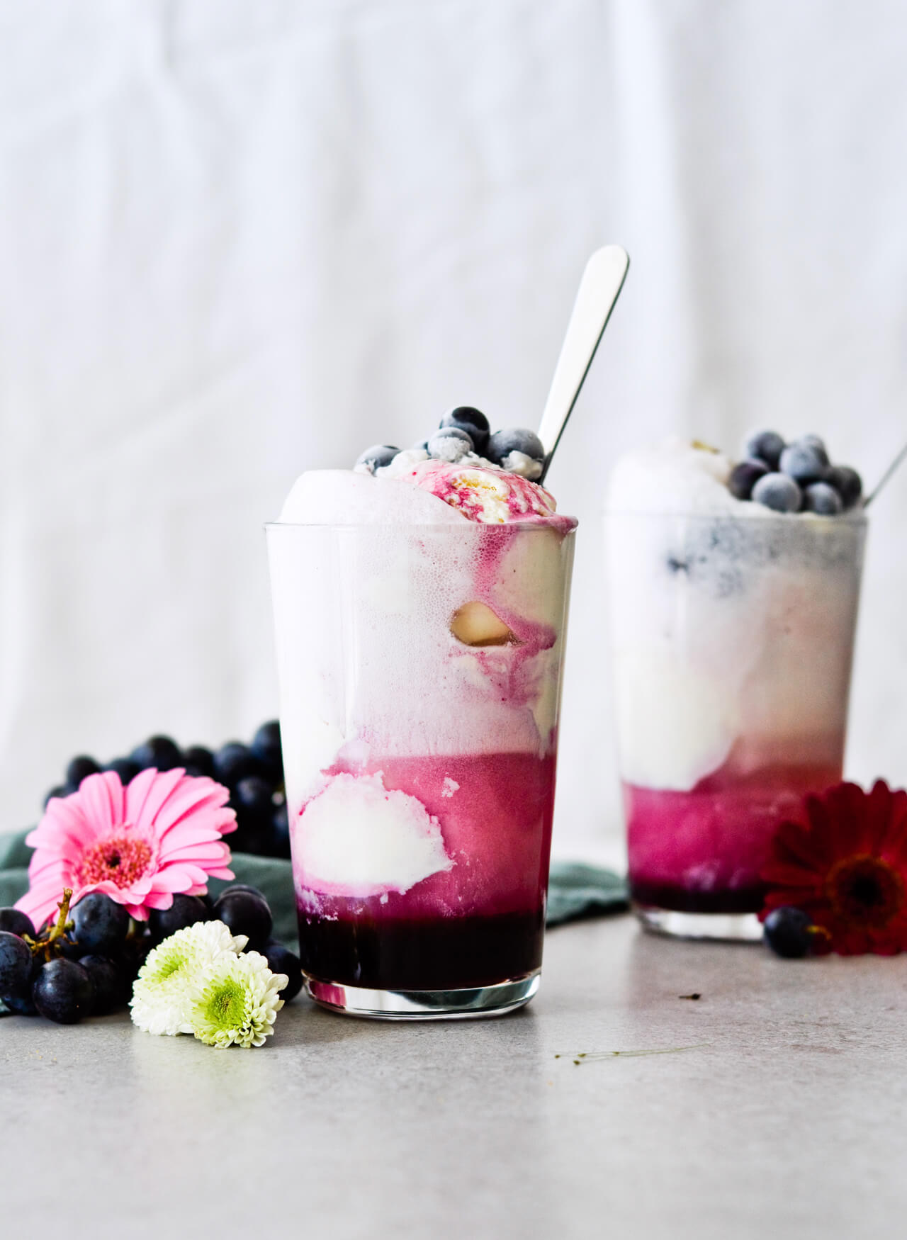 Concord grape syrup ginger beer floats will make you feel like a child again! Made with easy homemade syrup and lots of vanilla ice cream, these make the perfect early Fall - Autumn treat.