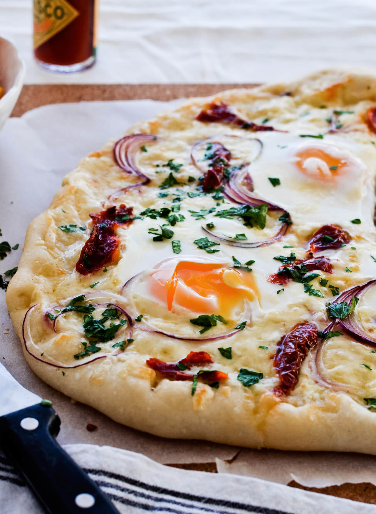 Easy vegetarian sun dried tomato onion breakfast pizza with eggs, easy brunch recipe that is quickly made.