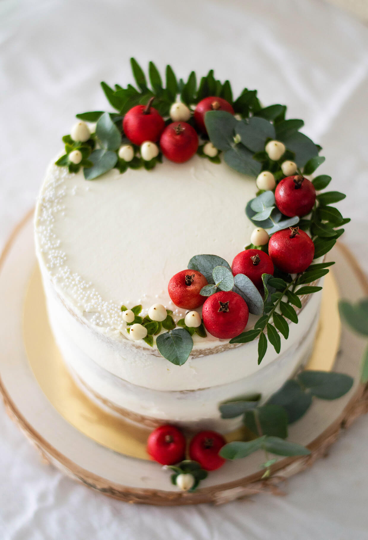 Top view of a layer apple cider cake, decorated with green leaves and mini red apples.