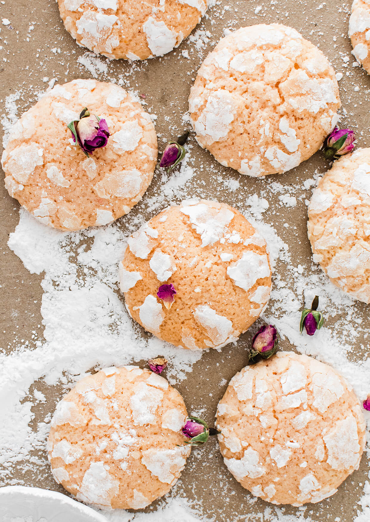 lemon crinkle cookies on paper with powdered sugar