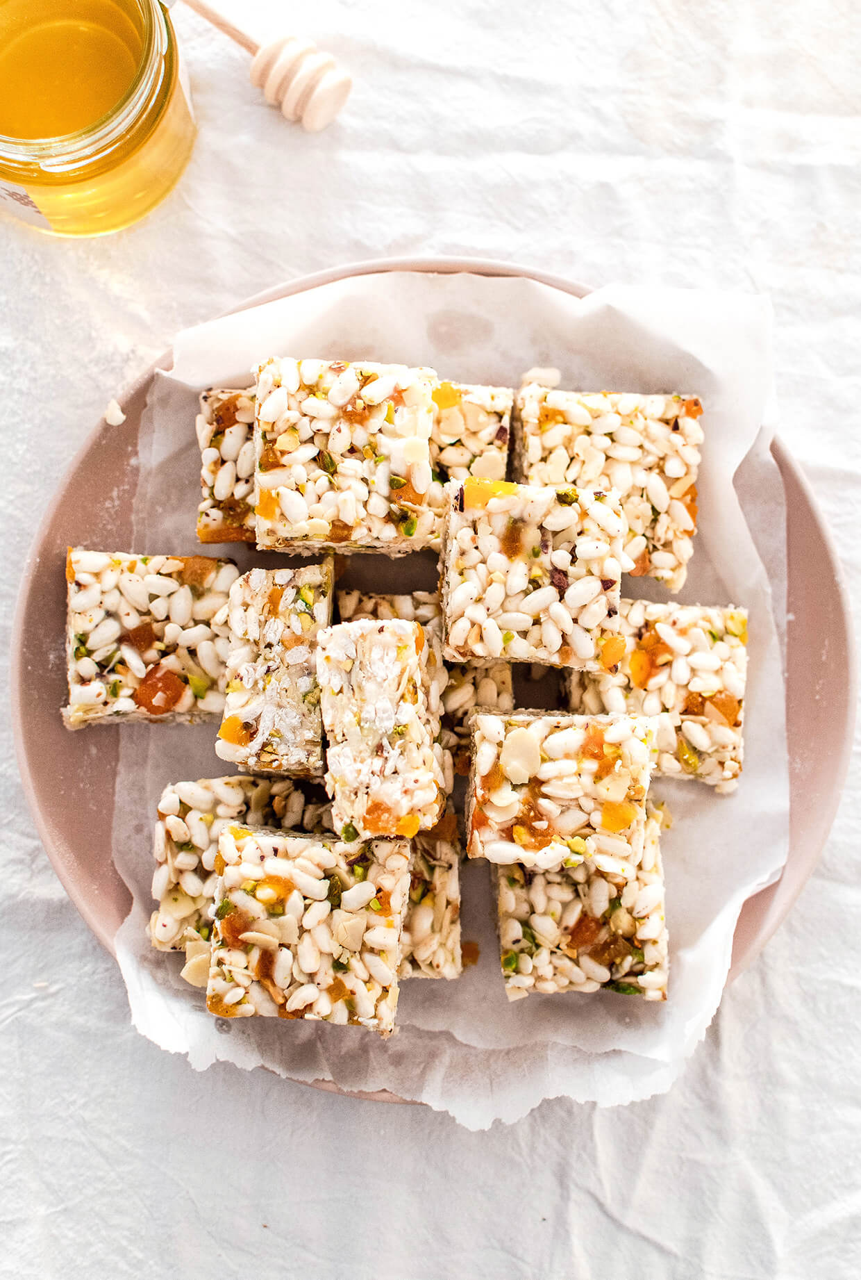 A picture of rice bars on a round plate - Chewy, crunchy and naturally sweet coconut apricot puffed rice bars, that make a perfect snack of breakfast addition. They involve zero baking, very little prep, a handful of ingredients and last for days.