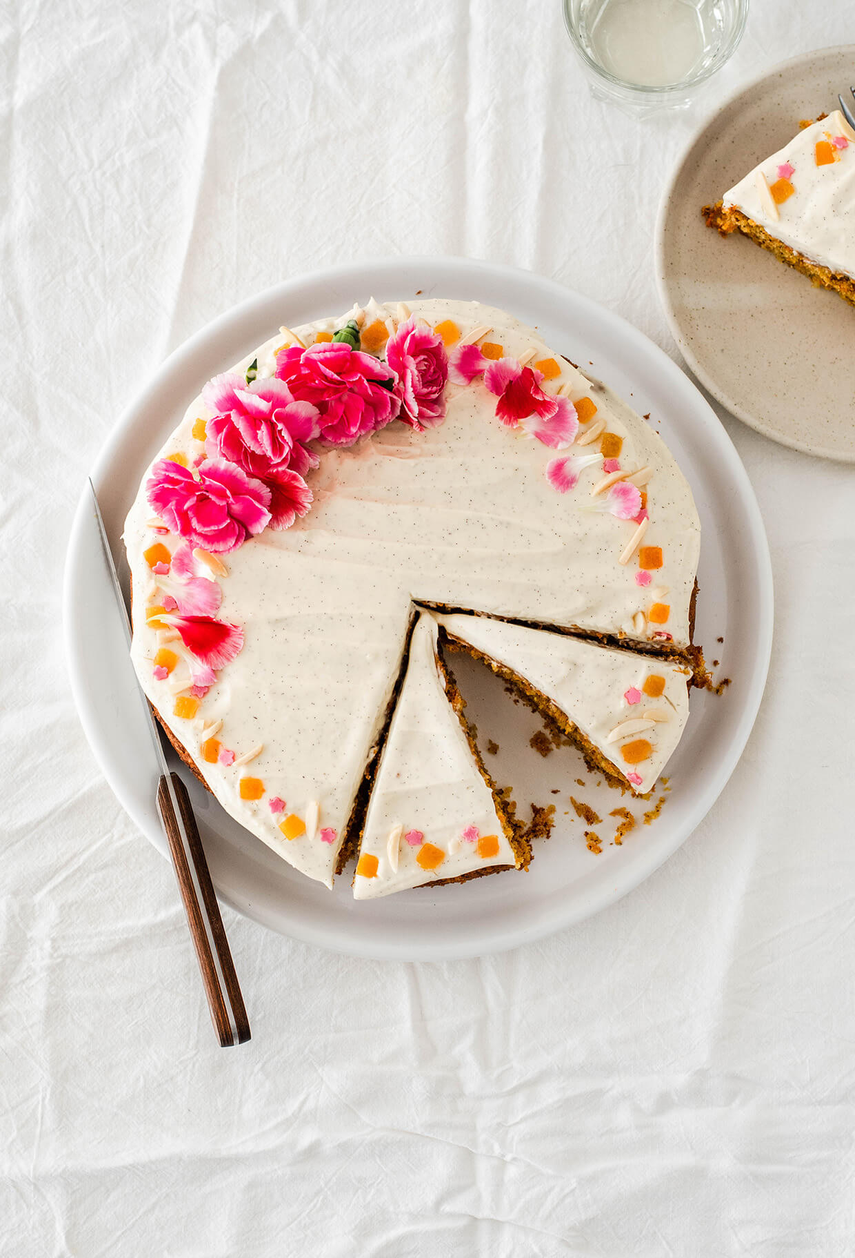 Orange almond carrot cake with creme fraiche frosting - single layer carrot cake with mascarpone creme fraiche on top, sliced on plate