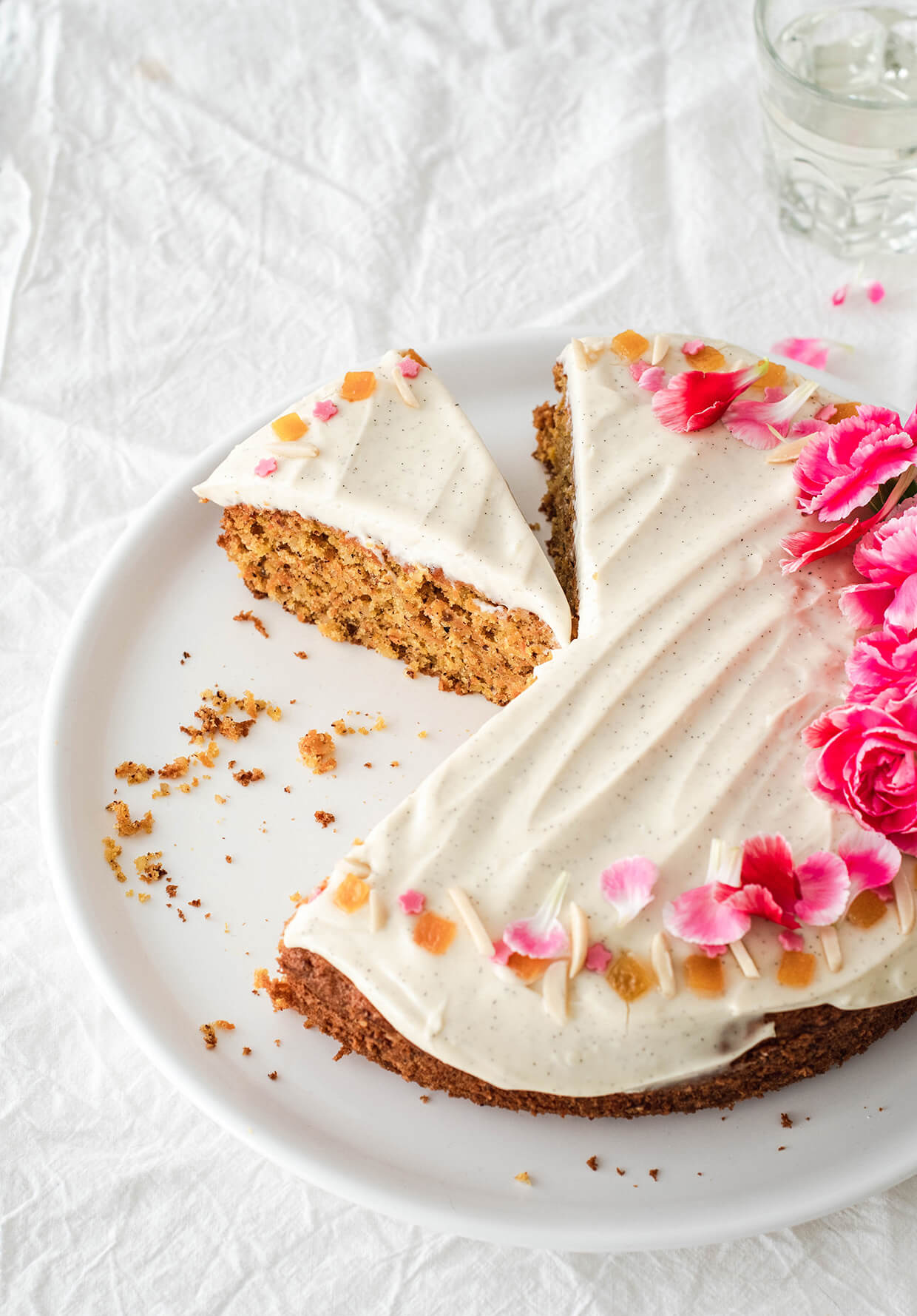 Recipe for Orange almond carrot cake with creme fraiche frosting - sliced cake on plate with flowers