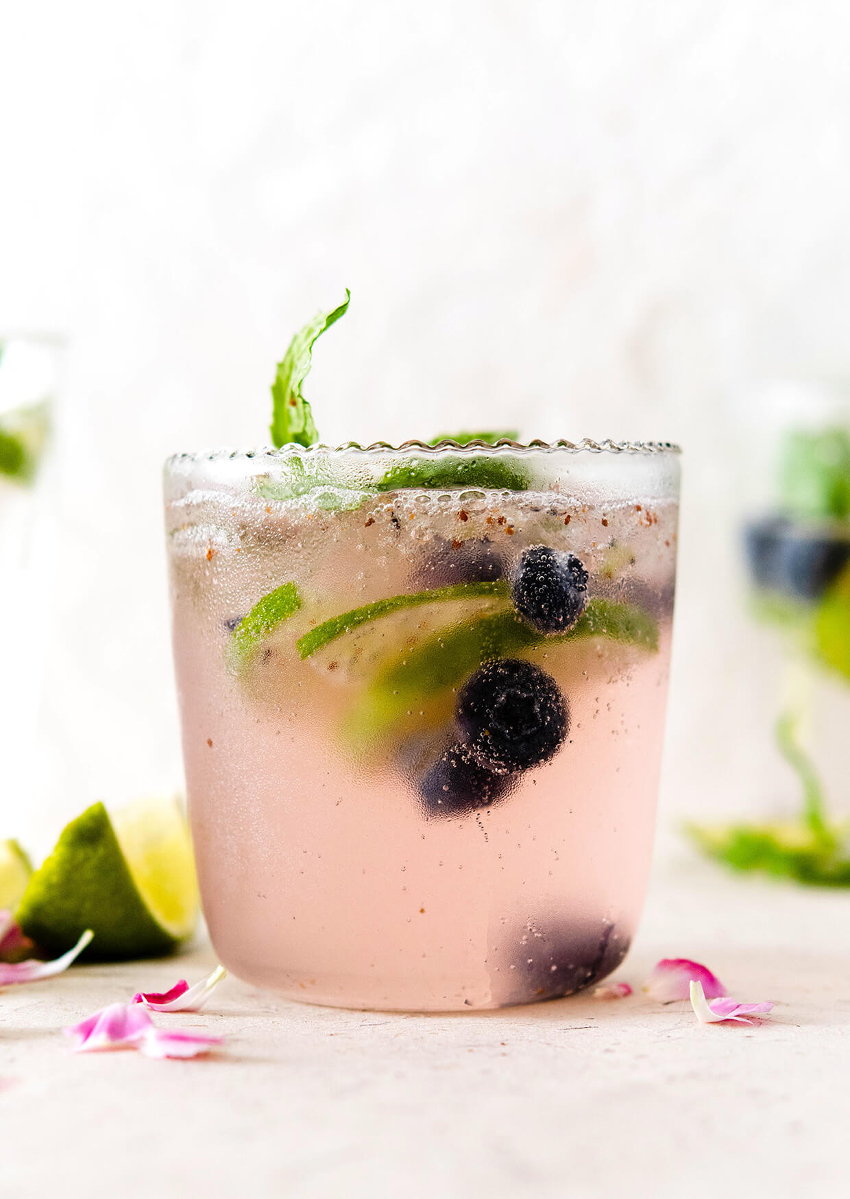 elderflower cocktail with blueberries and lime slices