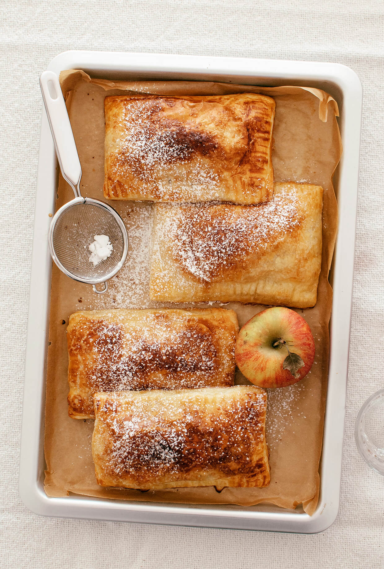 baking sheet with baked pastry apple pies