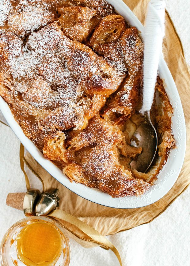 oval baking dish with bread pudding, spoon inside,