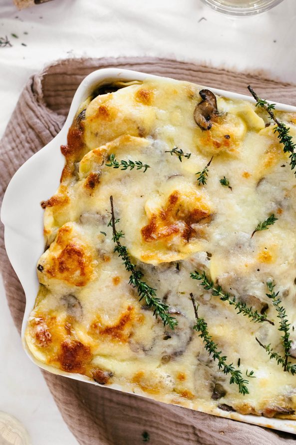 close shot of cheesy baked ravioli in baking dish