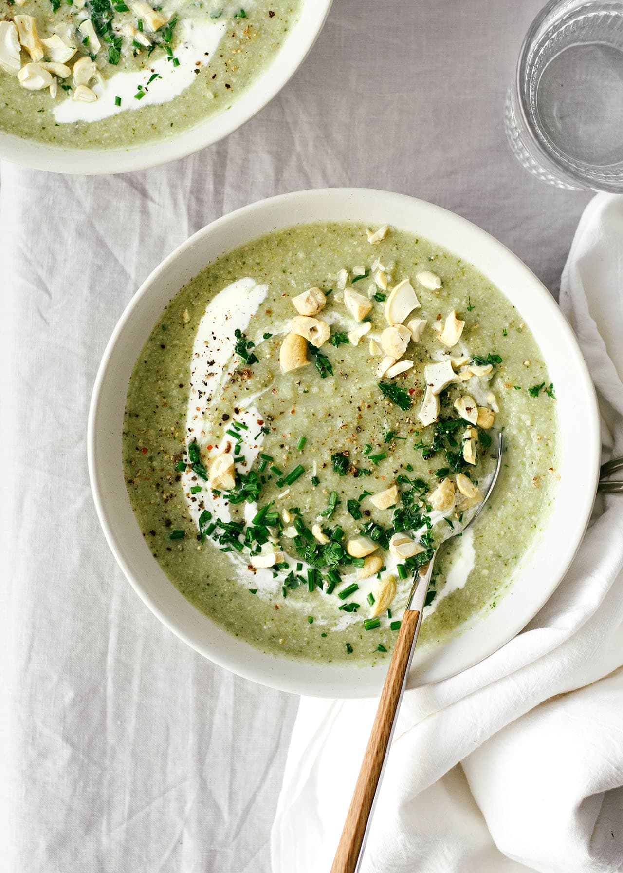 winter green soup served in bowls with chopped cashews and parsley on top