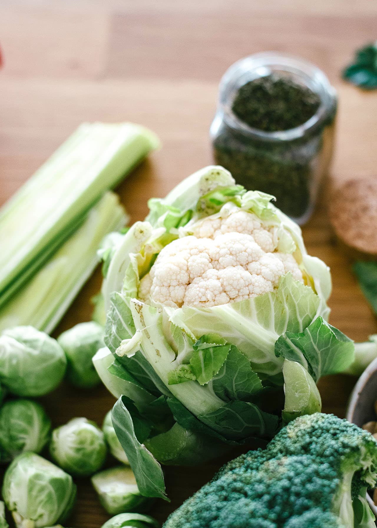 raw cauliflower head with cruciferous vegetables and dried thyme