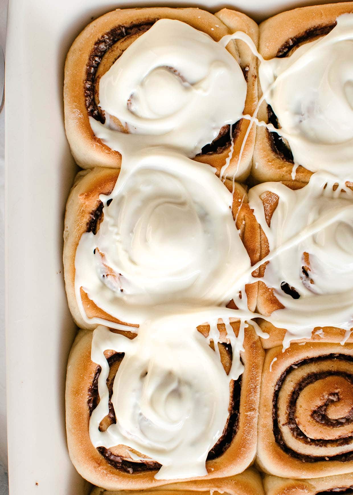 close view of white chocolate glaze cinnamon rolls