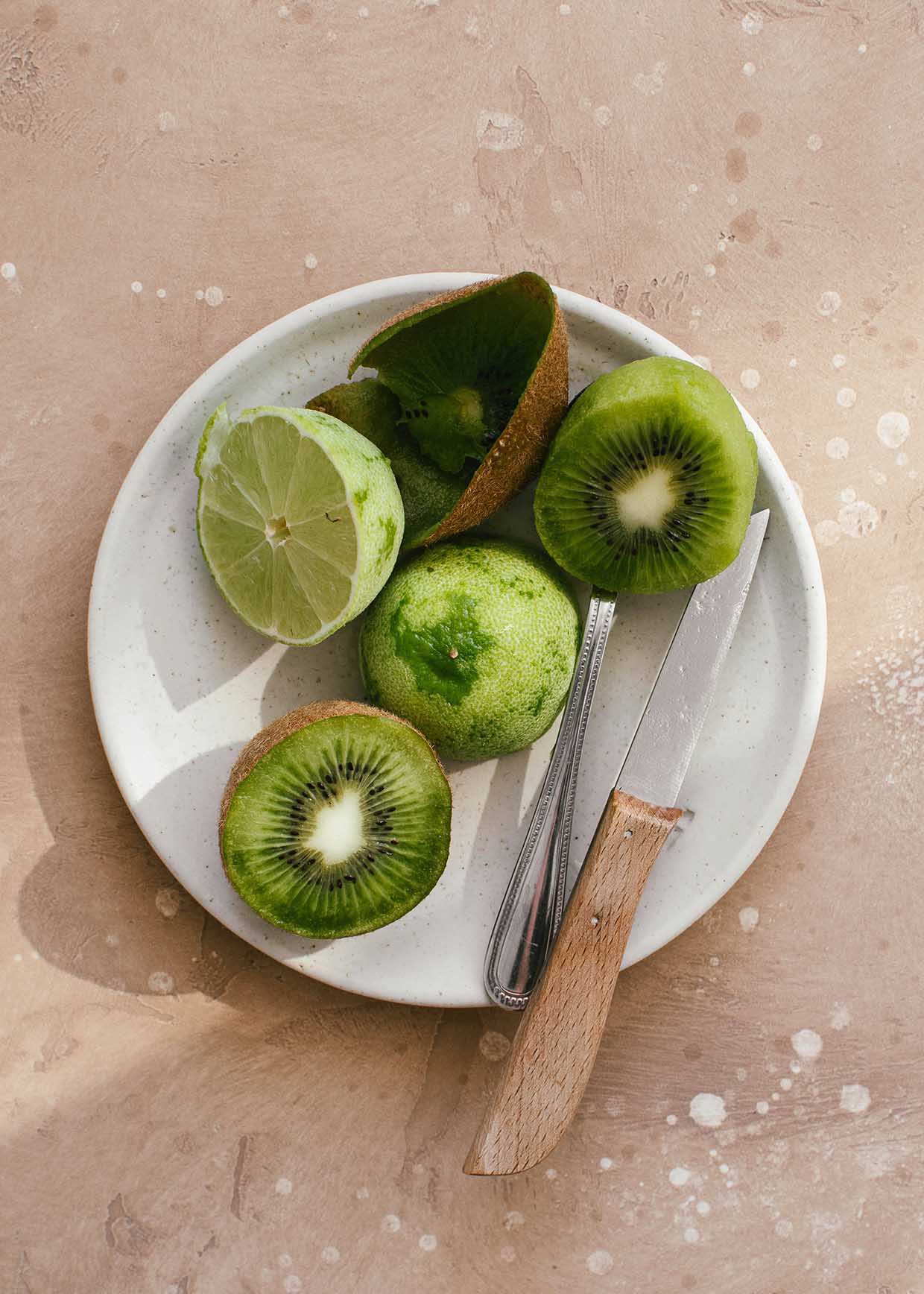 sliced kiwi fruit and lime on a plate 