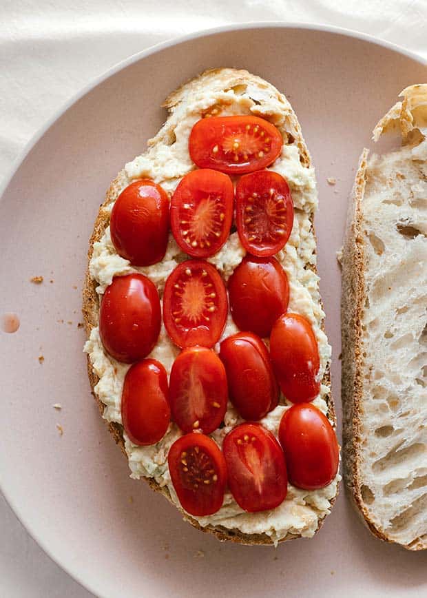 open chickpea sandwich with sliced tomatoes