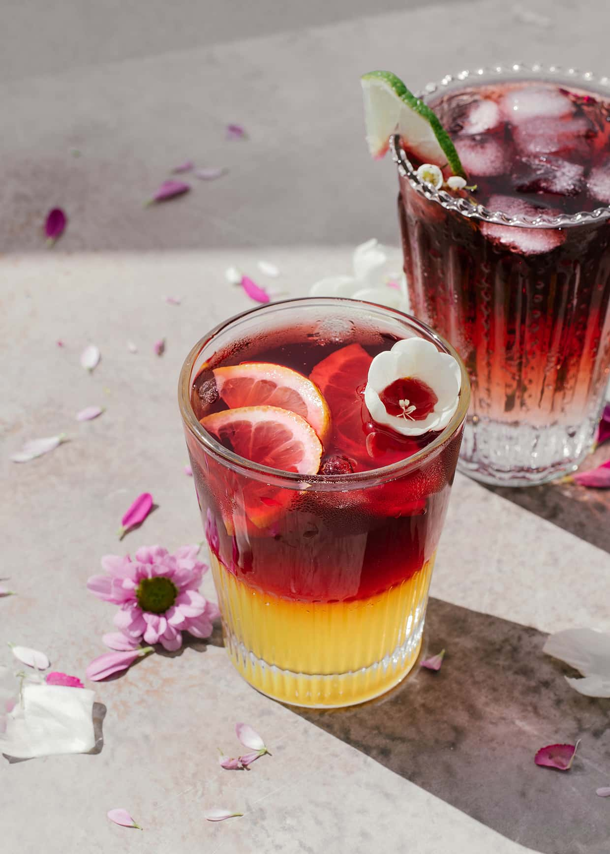 Glass filled with orange soda and red wine to make a red wine spritzer. With lemon sliced and ice.