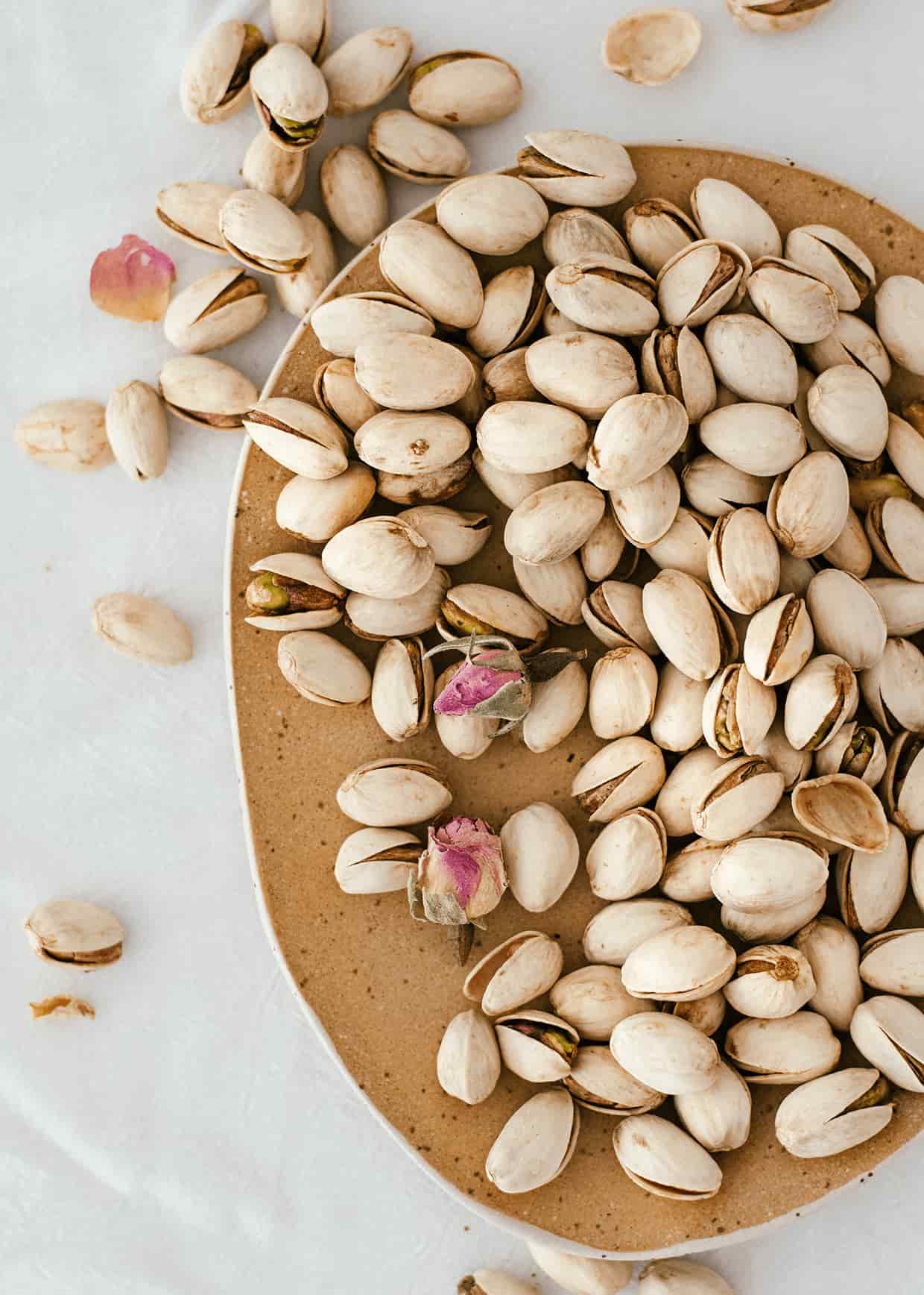 raw pistachio nuts in their shell placed on a plate