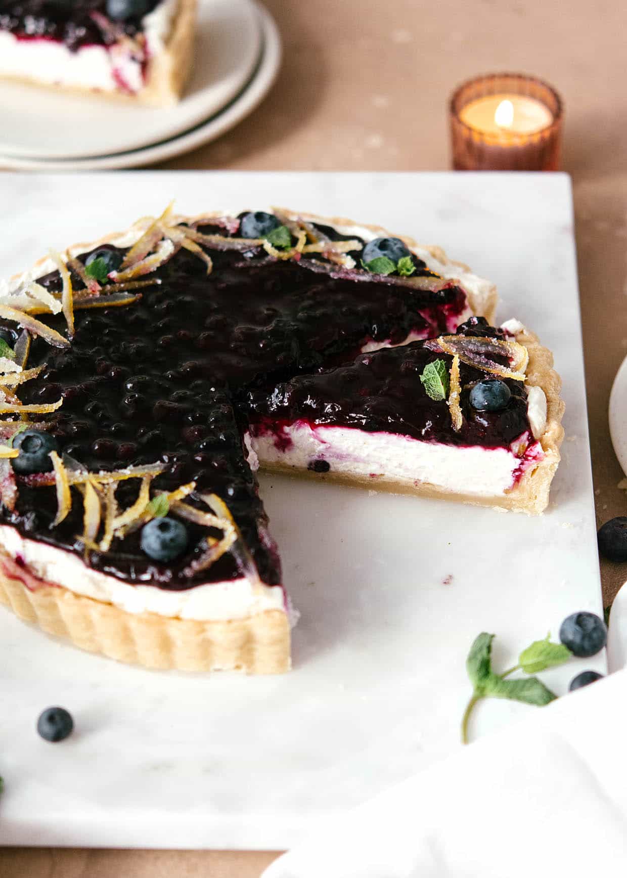 sliced mascarpone tart with blueberry jam topping